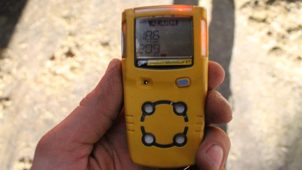 De loonwerkers zijn uitgerust met waarschuwingsapparatuur voor gevaarlijke gassen. Tijdens het mestrijden stond er weinig wind. En dat was duidelijk te merken. Vooral in de dode hoeken van de stal sloeg het apparaatje alarm.