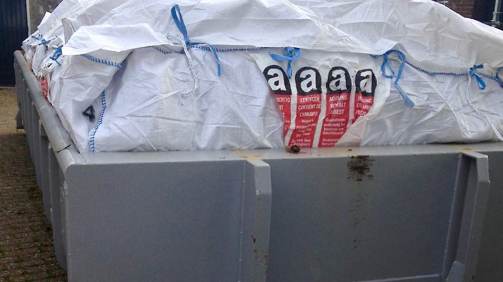 Een ingepakte container met asbest op een boerenerf.