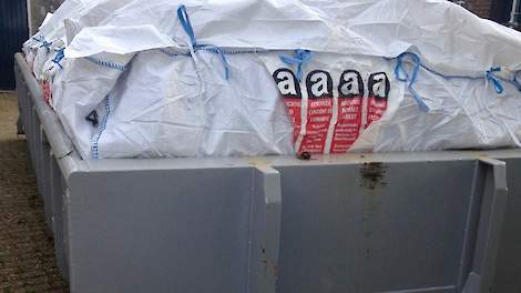 Een ingepakte container met asbest op een boerenerf.