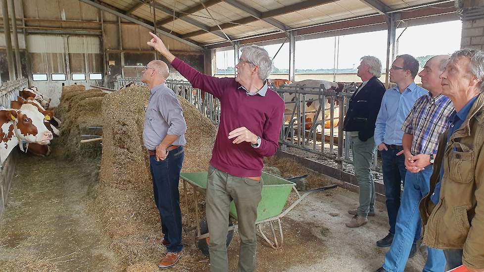 Onderzoeker Nico Ogink (midden) geeft uitleg over het onderzoek naar methaan in de stal bij Johan Vernooij (tweede van rechts) in Werkhoven.
