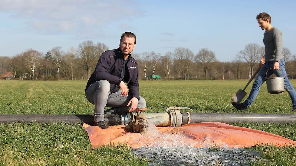 Daniël Nieuwenhuis van Waterschap Rijn en IJssel poseert bij één van de kranen. Erachter beent Robin Walvoort van voorheen proefboerderij De Marke voorbij met gereedschap voor de pomp.
