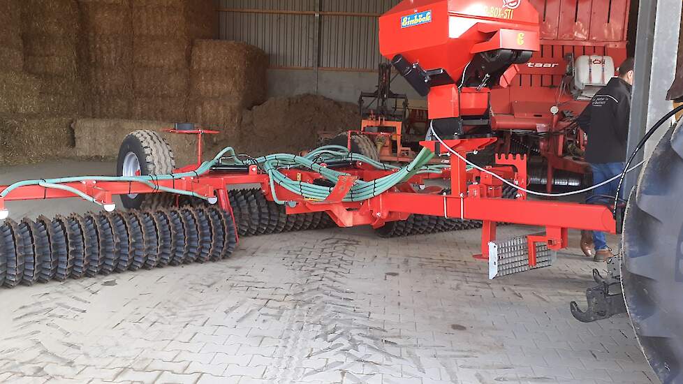 Achter de trekker hangt een zaaimachine en een rol. Deze rol drukt het graszaad in de grond, waardoor het uiteindelijk makkelijker kiemt. De vorm van het uiteinde van de rol heeft veel weg van een schapenhoef en draagt daarmee bij aan het uitstoelen van h