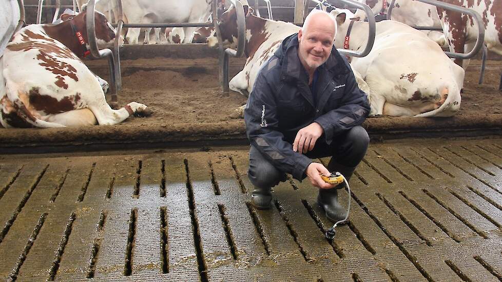 Gerrit Stobbelaar bezig met een ammoniakmeting onder de roostervloer.