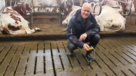 Gerrit Stobbelaar bezig met een ammoniakmeting onder de roostervloer.