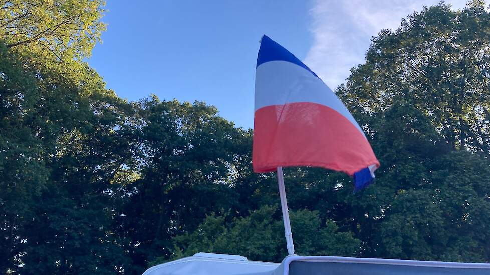 Een vakantieganger heeft een kleine omgekeerde Nederlandse vlag aan de voortent gemonteerd.