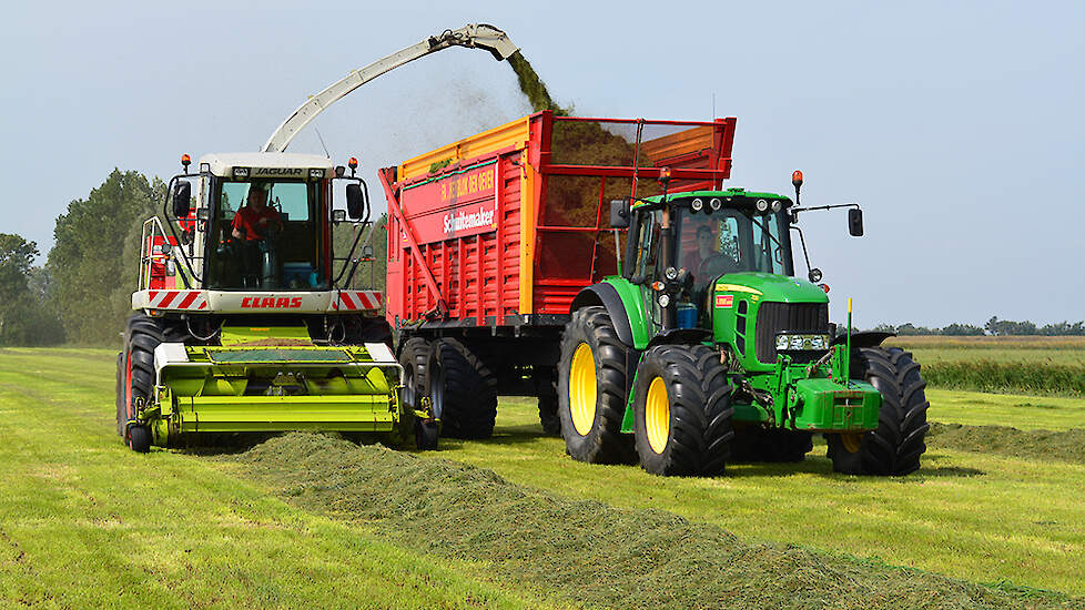 Claas hakselaar en John Deere trekker met silagewagen