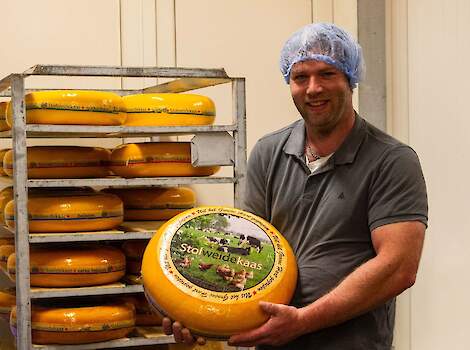 Gert-Jan Snoek met eigen boerenkaas op de foto. Hij staat in een kaasopslag