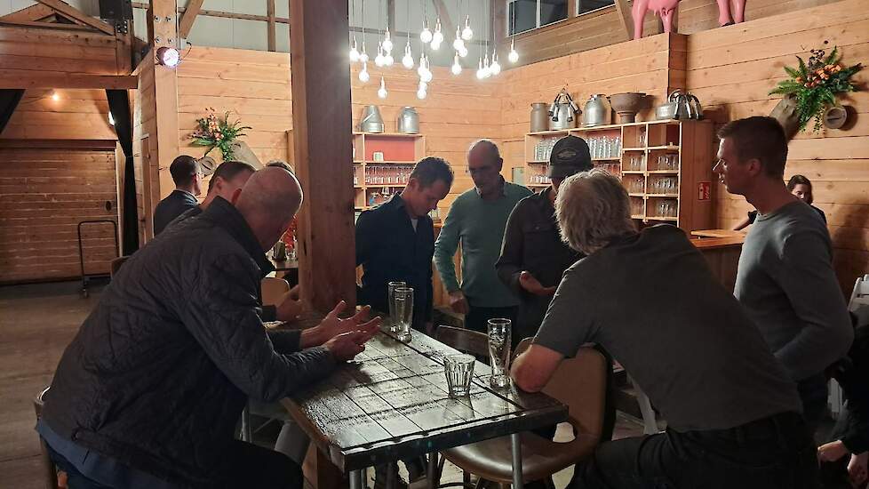 Bezoekers praten met experts en collega’s tijdens de borrel.