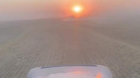 Ochtendzon op land tijdens stoffige gerstoogst, zicht uit de trekkercabine