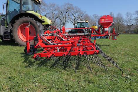 Een wiedeg aan het werk in een graslandperceel.