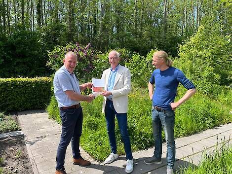 Thom Miedema (voorzitter Agricycling, links) overhandigt de maatschappelijke rapportage 2025 aan Jan Dijkstra (wethouder Waadhoeke) onder toeziend oog van Jan Woudstra (bestuurslid Agricycling).