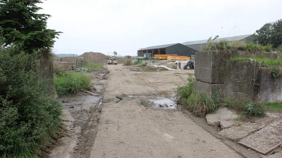 Op verschillende plekken op het erf is nog de oude waterkering te zien, zoals hier tussen de oude stal en de kuilen. In de opening tussen de betonblokken kan bij hoog water een zware metalen deur worden geschoven.