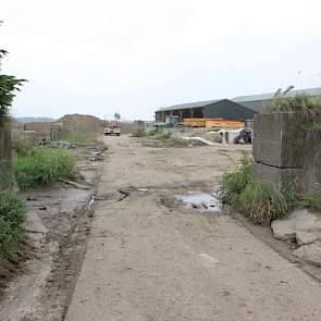 Op verschillende plekken op het erf is nog de oude waterkering te zien, zoals hier tussen de oude stal en de kuilen. In de opening tussen de betonblokken kan bij hoog water een zware metalen deur worden geschoven.