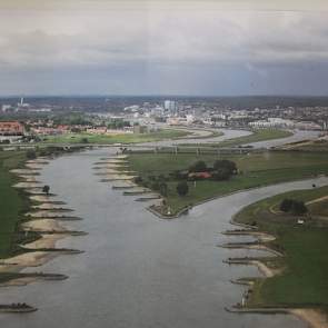 Het bedrijf van Ton Reijers, in het midden van de foto, is ingeklemd tussen de Rijn (links) en de IJssel (rechts). 's Winters loopt de huiskavel volledig onder.