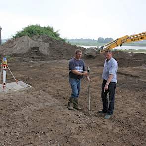 De laatste hand wordt achter de stal nog aan de terp gelegd. Op de achtergrond de Rijn. Rechts Ton, links zijn neef Victor waarmee hij samenwerkt.