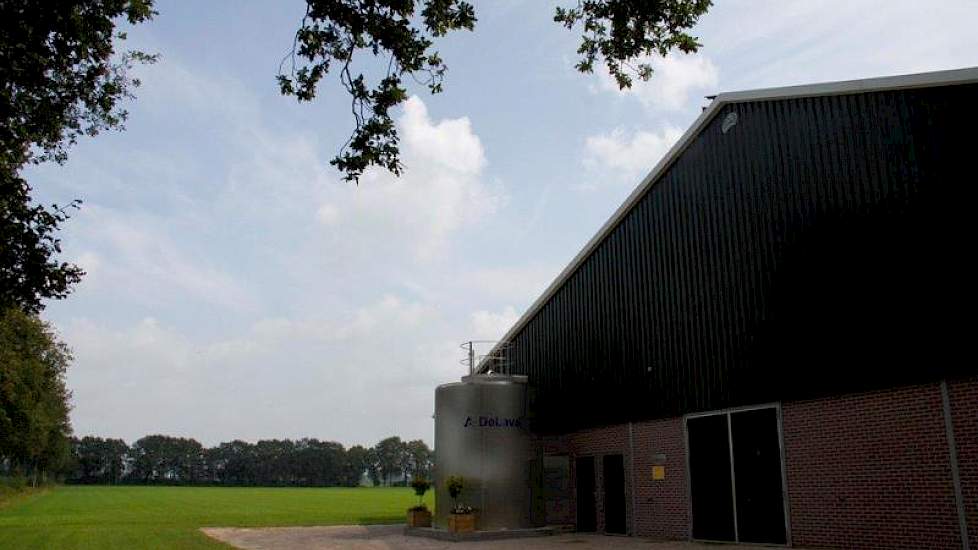 Het vooraanzicht van de stal met de vertikale silotank.