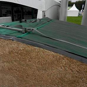MBS-beton presenteert haar nieuwe ‘Silage Safe' afdeksysteem. Aan weerszijden worden om de twee meter stroken kunststof doek gelegd. Aan de linkerkant zit een spanband en aan de rechterkant een stalen buis. Door de spanbanden aan te trekken worden de twee
