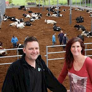 Arjan Geenen (41) en Janneke Suij (38) met op de achtergrond hun 'hulpboeren' in de nieuwe vrijloopstal.