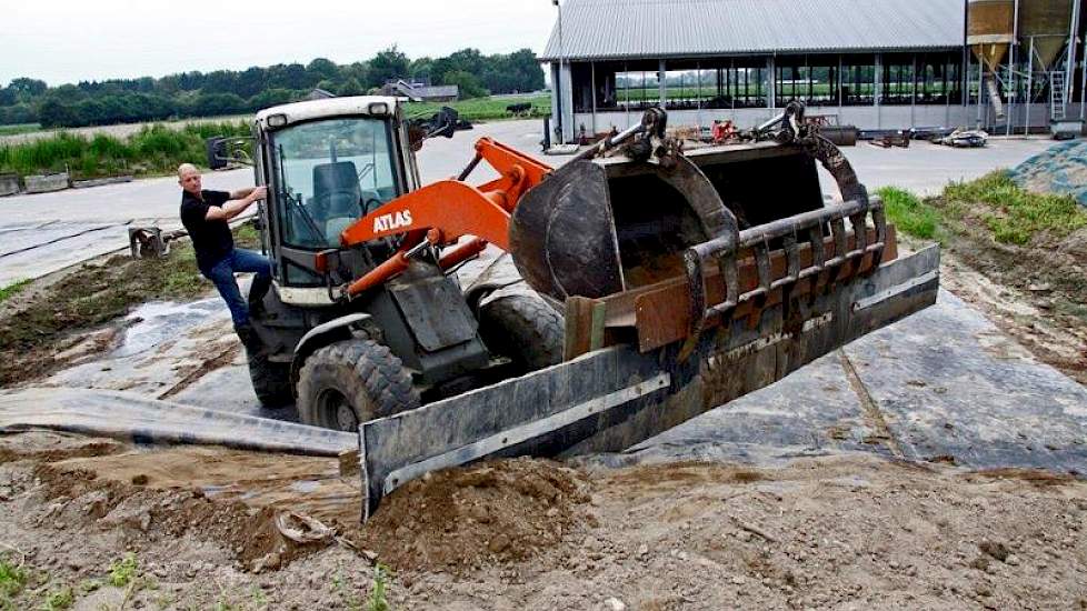 Erik Borkus uit Kilder (GD) bedacht vorig jaar een schuif met rubberen flap om zand van de kuil te vegen. Met de klem van zijn voerbak pakt hij het zes meter brede gevaarte vast zonder uit de shovel te stappen. „Er zijn nu soortgelijke oplossingen op de m